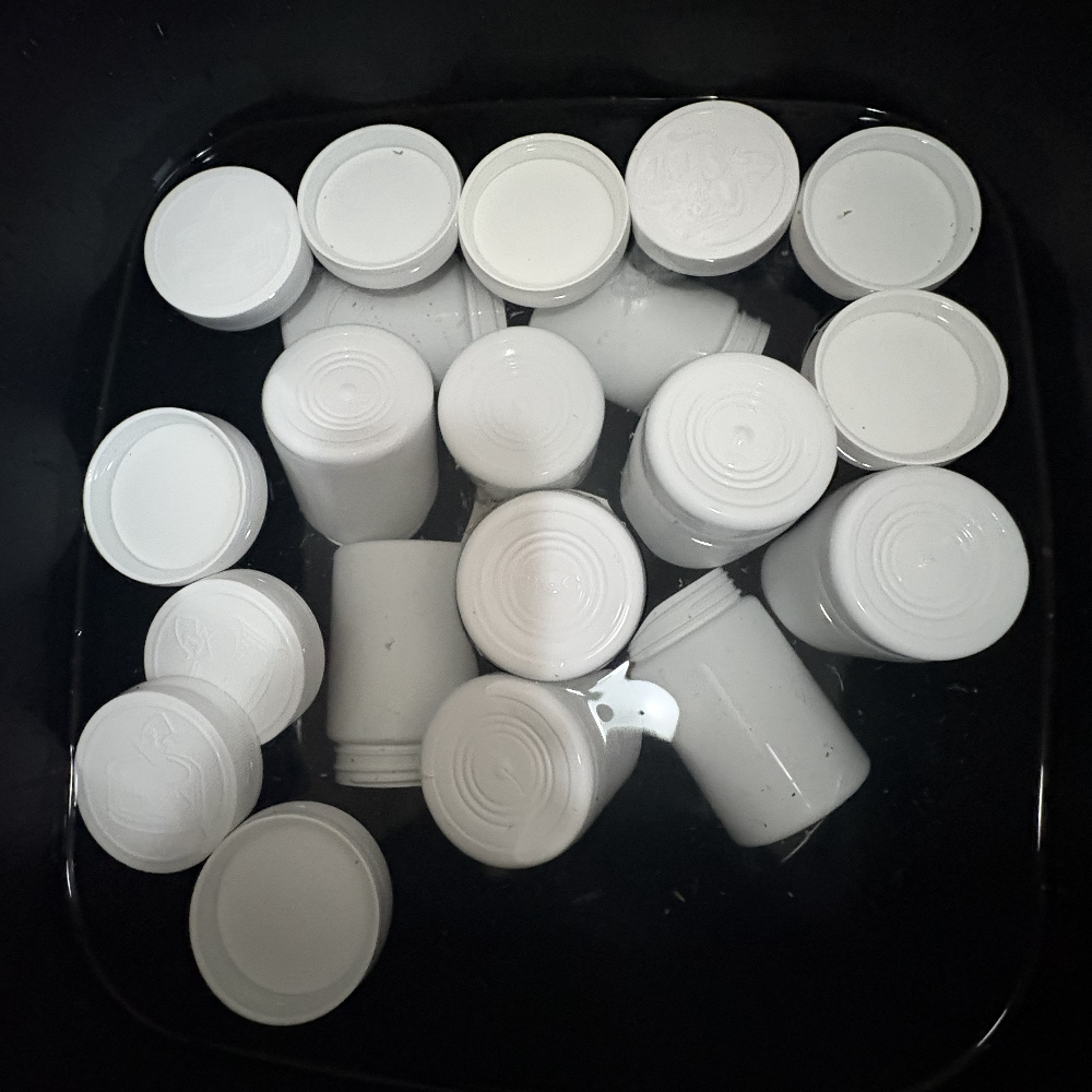 Containers soaking in a diluted bleach solution to lift old labels.