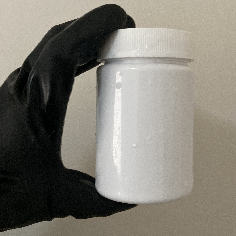 Gloved hands wiping a container with an alcohol sanitising cloth.