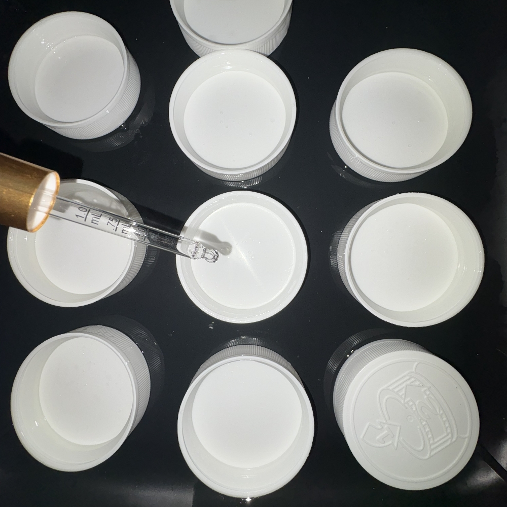 Applying a drop of essential oil to the inside of a jar lid.